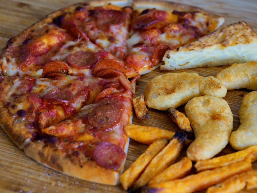 A close-up shot of pizza, Spanish omelette, sweet potato fries, and nuggets on a wooden table.
